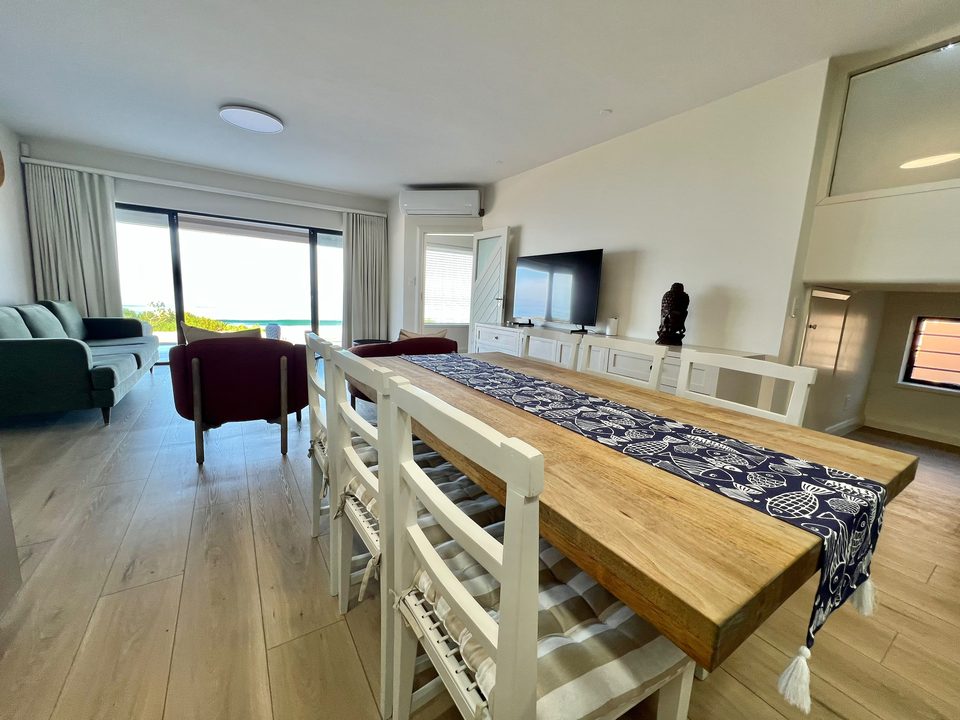 The long table and lounge of the bottom unit with the sea beyond